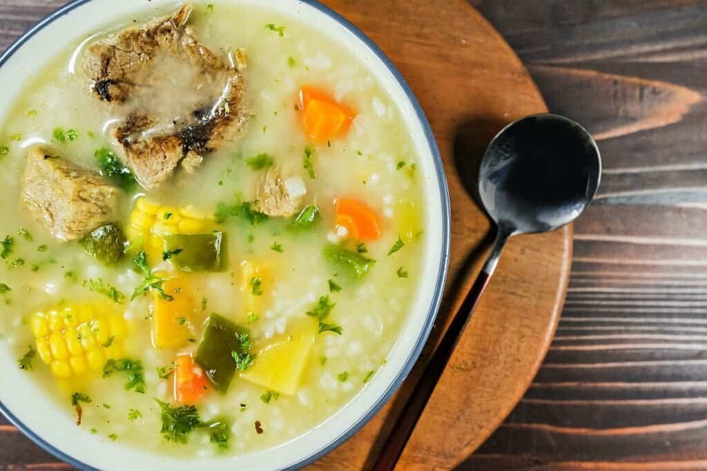 Recetas Tradicionales de República Dominicana - a bowl of soup with a spoon